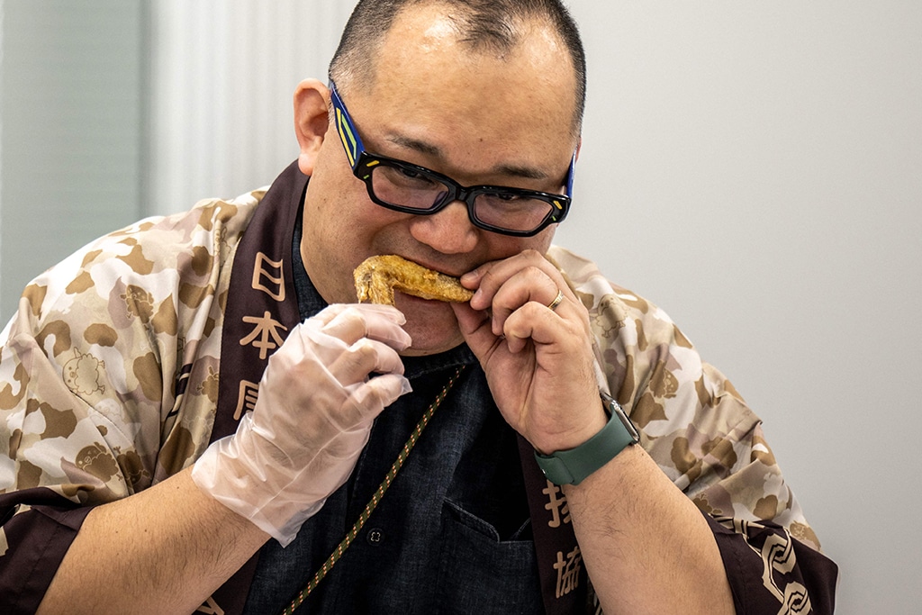 This picture shows Japan Karaage Assosiation executive director Kouichirou Yagi eating a chicken wing during the Karaage Grand Prix competition in Tokyo.