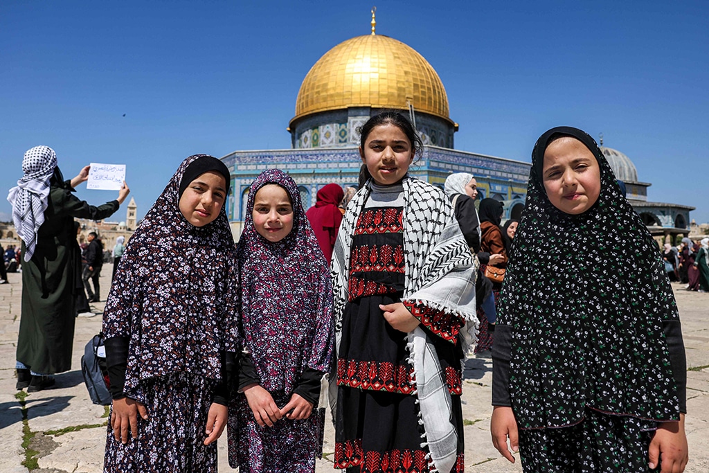 Young female Muslim worshippers pray during the fourth Friday Noon prayers of the holy fasting month of Ramadan outside the Dome of the Rock mosque at the Al-Aqsa mosque compound.