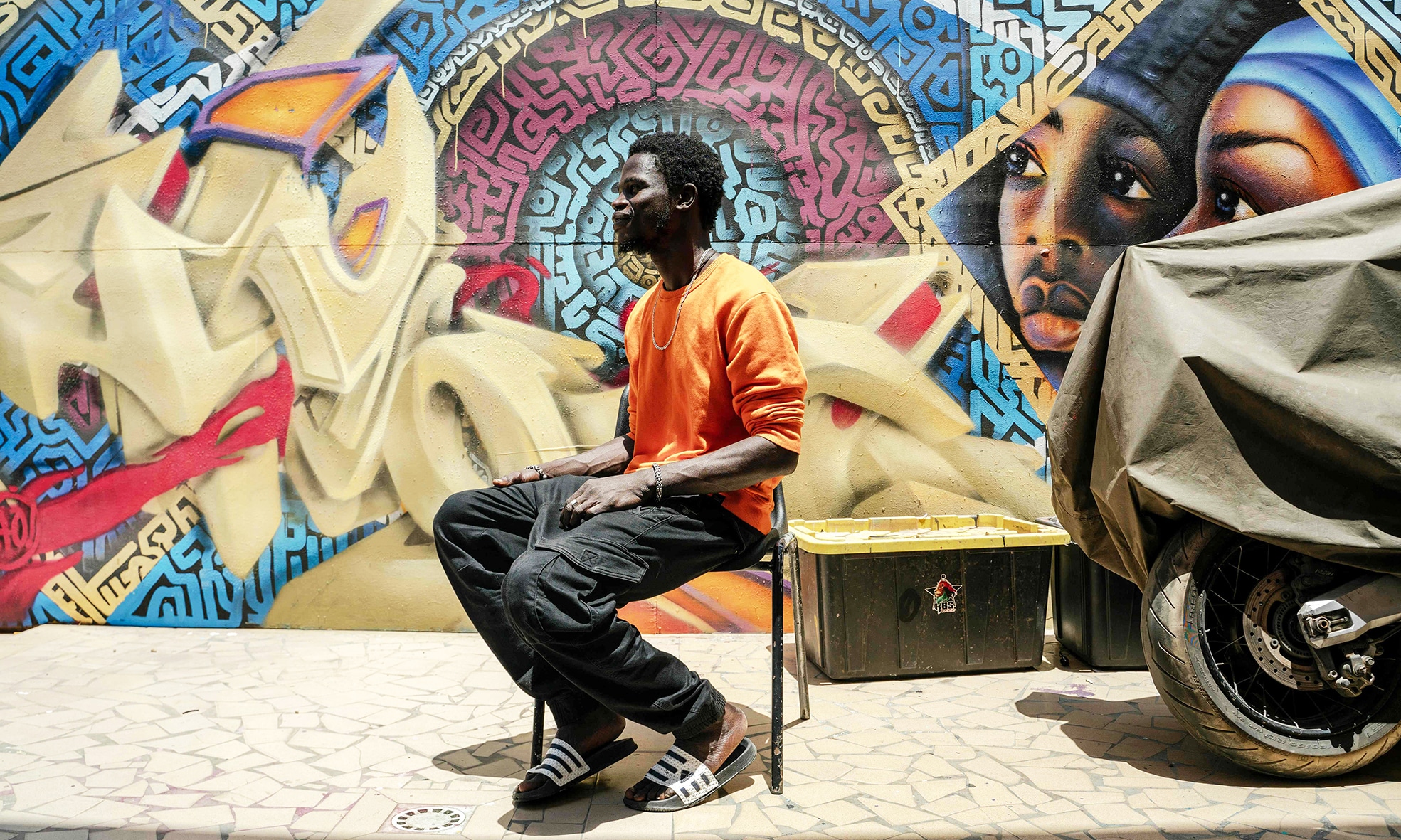 An artist is sitting in the schoolyard at RBS Akademya.
