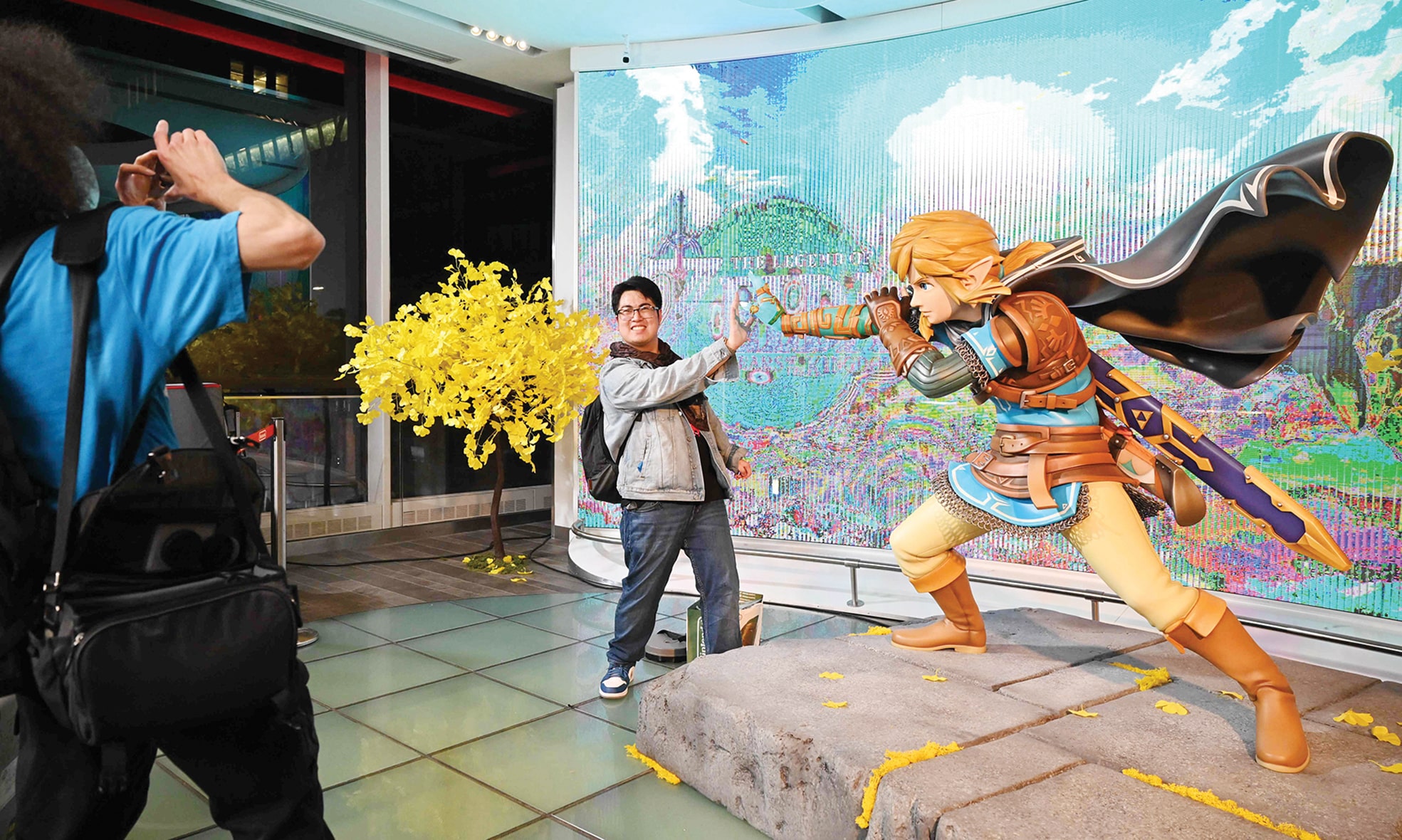 A customer poses for a photo with Zelda's character Link after purchasing 'The Legend of Zelda: Tears of the Kingdom'.