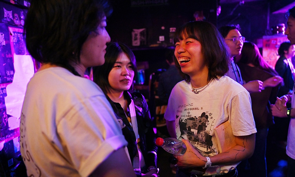 This photo shows lead singer Yuetu (right) of punk band Xiaowang chatting with her bandmates, guitarist Qiuqiu (left) and drummer Zaozao (center), before a performance at a club in Beijing.