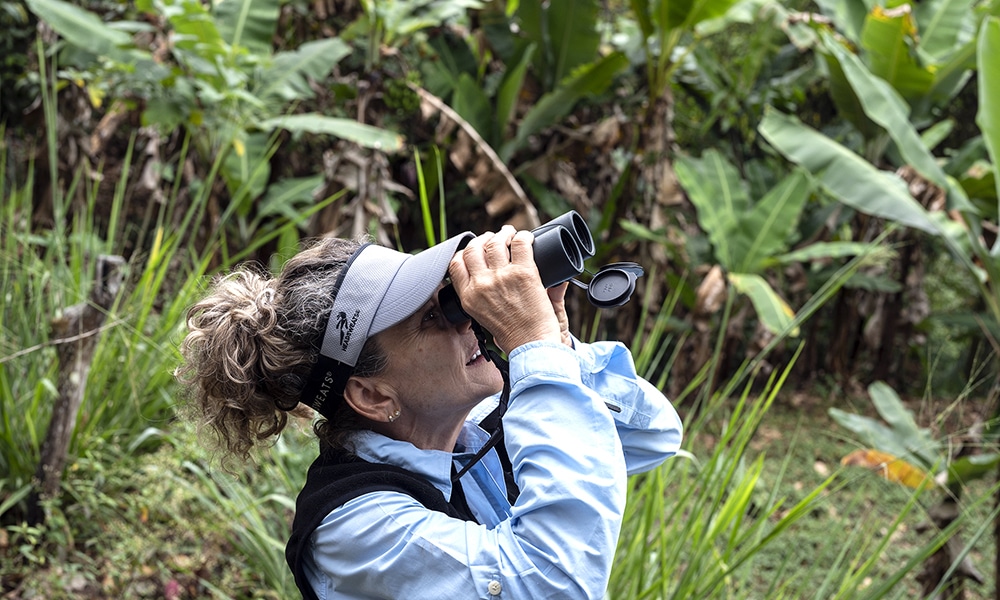 A woman uses binoculars to watch birds during a birdwatching mission that visits the natural forest at the Amaranta Casa de Colibries sanctuary in San Jose de Los Altos, Miranda State, Venezuela.--AFP photos