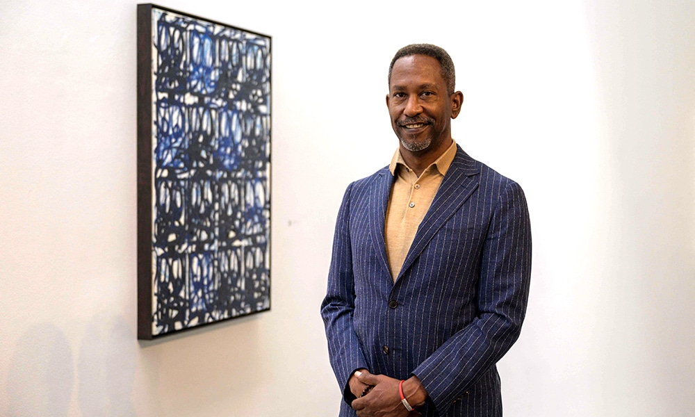 Brent Leggs, Executive Director of the African American Cultural Heritage Action Fund, poses next to Rashid Johnson's Bruise Painting 'Nina's Blues' displayed as part of the Nina Simone Childhood Home Auction Exhibition.