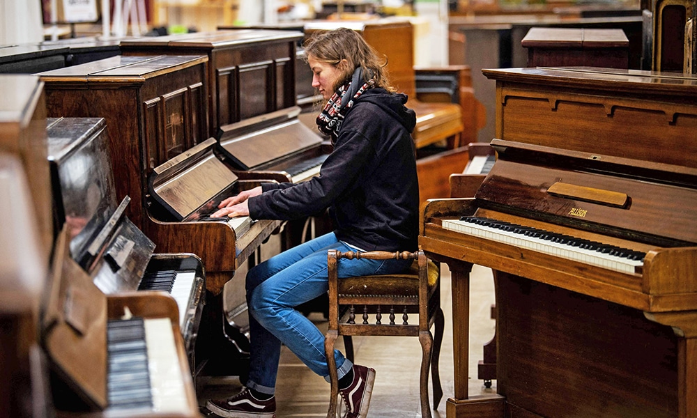 Volunteer staff member Shona MacArthur tries a piano at the Pianodrome.