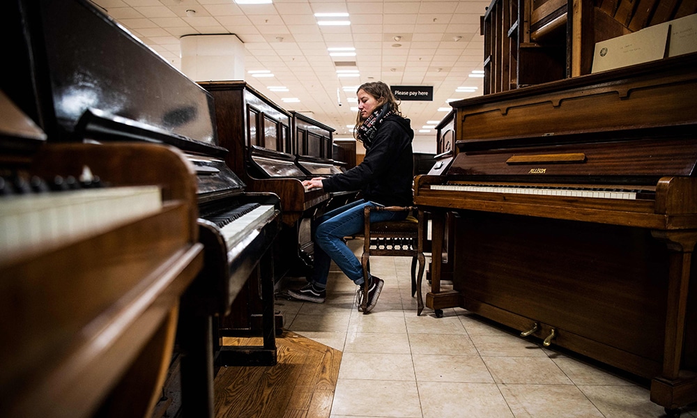 Volunteer staff member Shona MacArthur tries a piano at the Pianodrome.