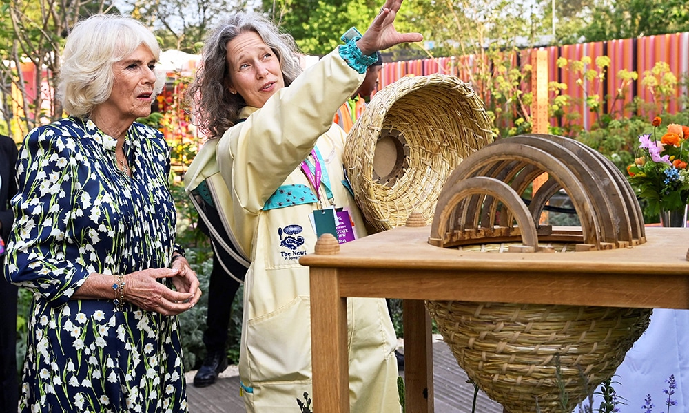 Britain's Queen Camilla views a bee house with beekeeper Paula Carnell during a visit to the 2023 RHS Chelsea Flower Show.
