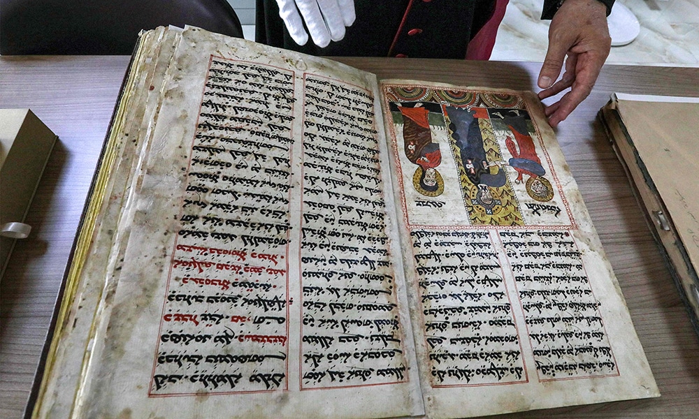 The Chaldean Catholic Archbishop of Mosul Michaeel Najeeb presents an old Syriac-language Christian codex at the Eastern Manuscript Digitisation Centre (CNMO) in Arbil.