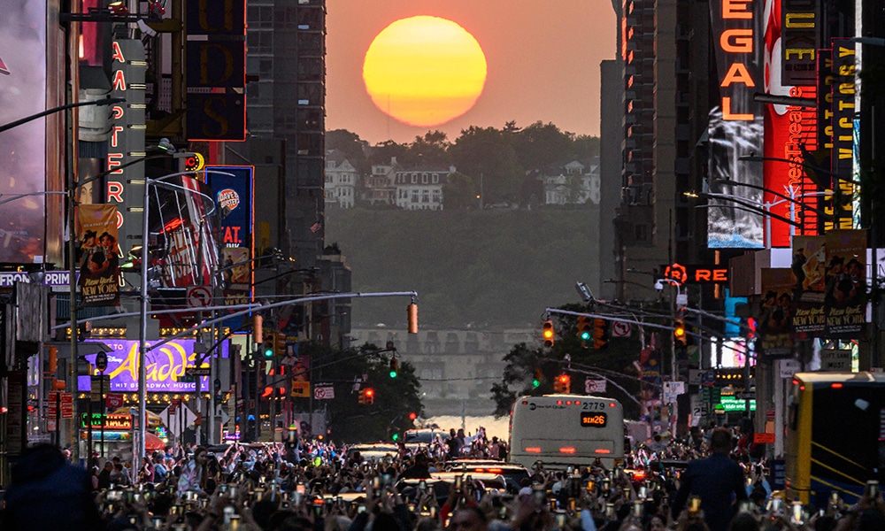 The Sun sets in alignment with Manhattan streets running east-west, also known as Manhattanhenge, in New York City.