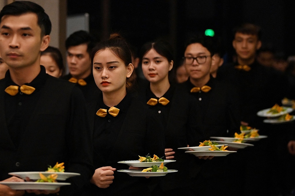 Waiters prepare to serve dishes at the Michelin Guide ceremony in Hanoi .