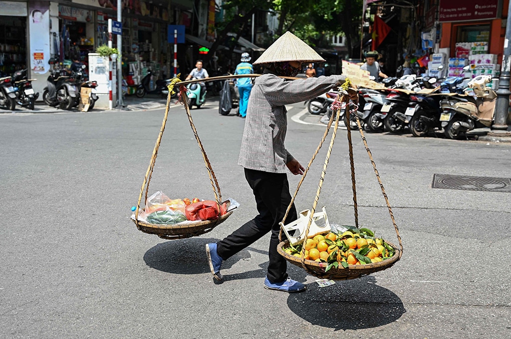 A street vendor carries oranges in Hanoi.
