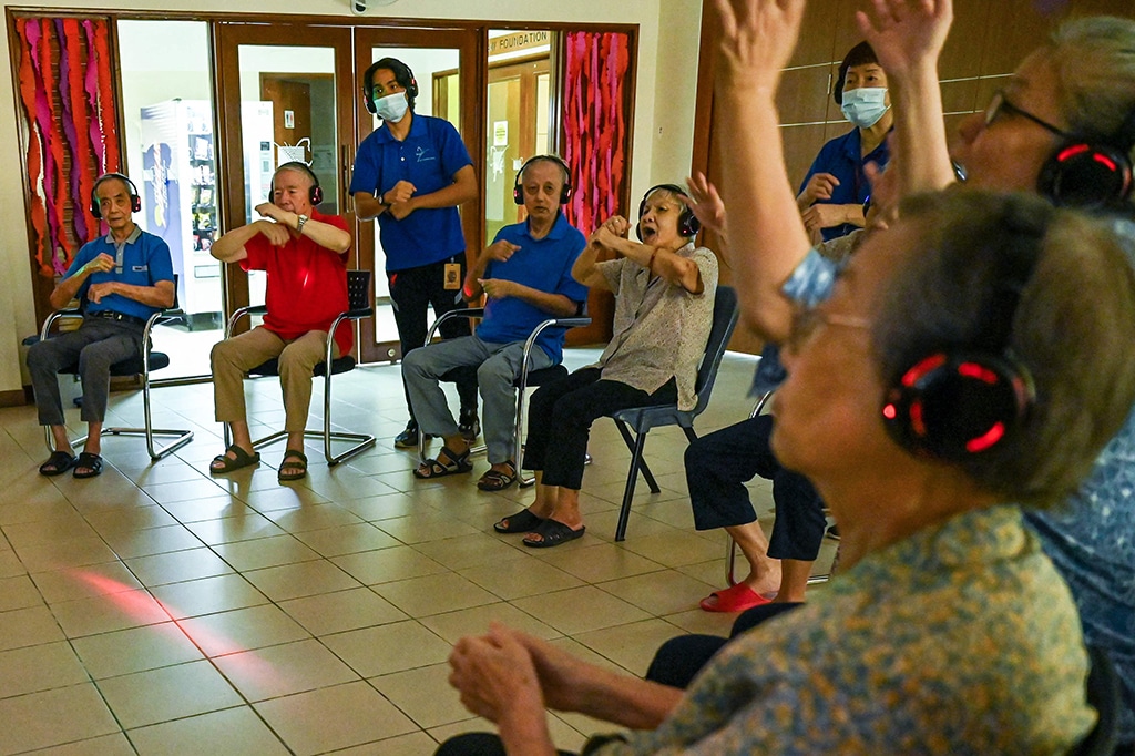 Residents with dementia participating in a silent disco at Apex Harmony Lodge in Singapore.