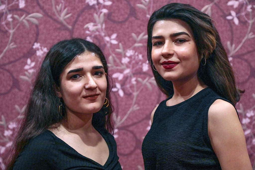 Syrian-Kurdish refugees and musicians Norshean Salih (right), 23, and her sister Perwin Salih, 20, pose for a photograph in Arbil, the capital of the autonomous Kurdish region of northern Iraq.--AFP photos