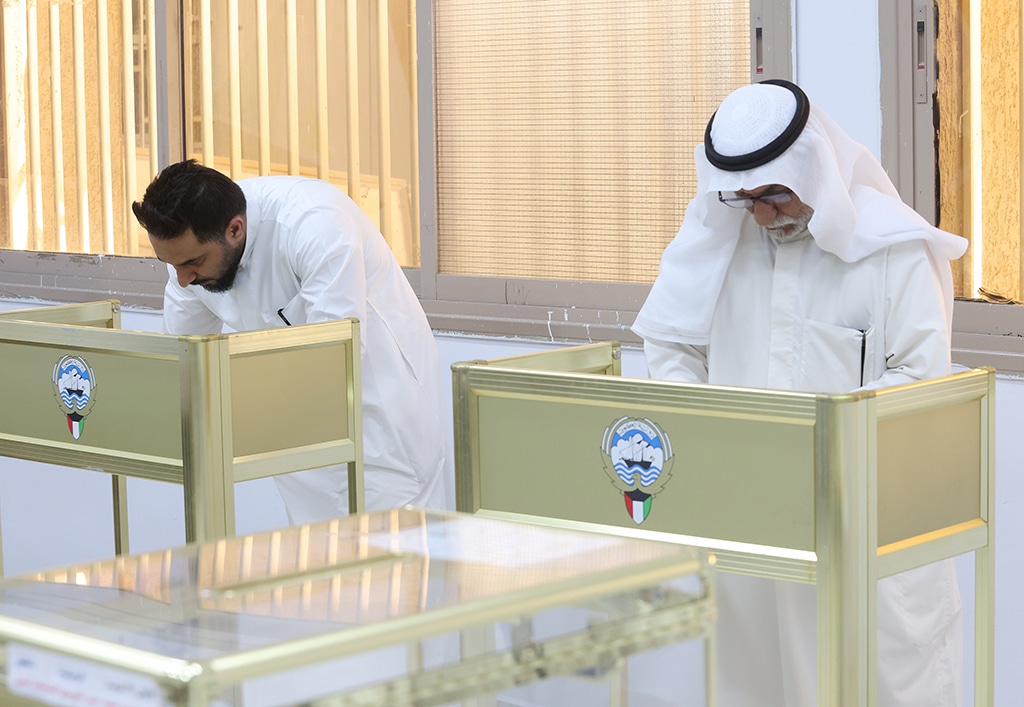 Kuwaiti men cast their votes during parliamentary elections in Kuwait City on June 6, 2023.