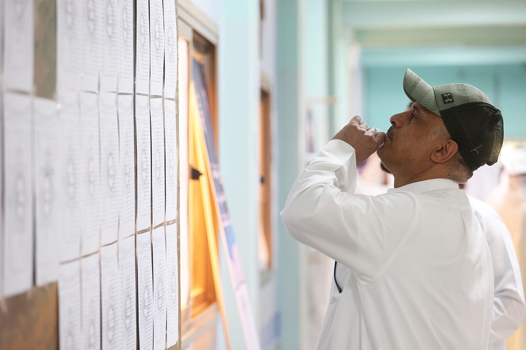 Kuwaiti men check voting lists at a polling station during parliamentary elections in Kuwait City on June 6, 2023.