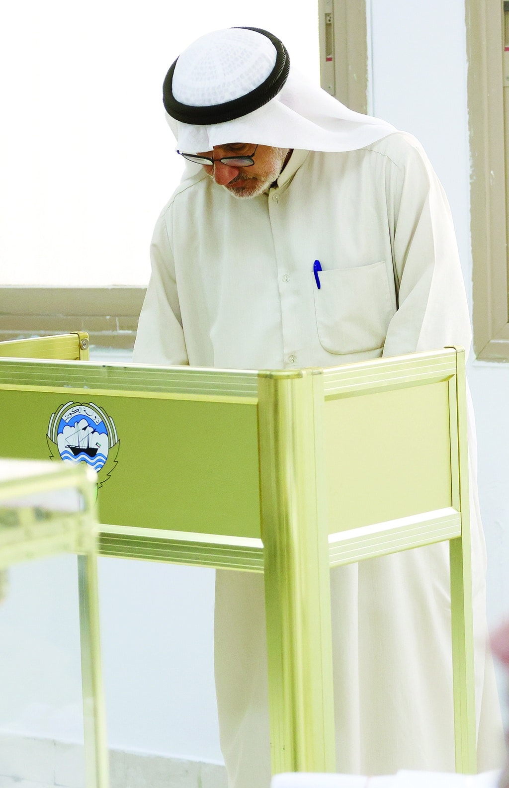 Kuwaiti men cast their votes during parliamentary elections in Kuwait City on June 6, 2023.