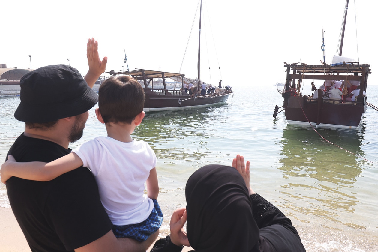 KUWAIT: Family members of a Kuwaiti youth wave as traditional dhows prepare to sail for a pearl diving expedition from the shore of Kuwait City on August 12, 2023. Pearl-diving trips are held annually in summer under the patronage of Kuwait’s Amir, in order to keep alive an ancestral heritage of pearl diving and trading, prior to the discovery of oil. - Photo by Yasser Al-Zayyat and KUNA